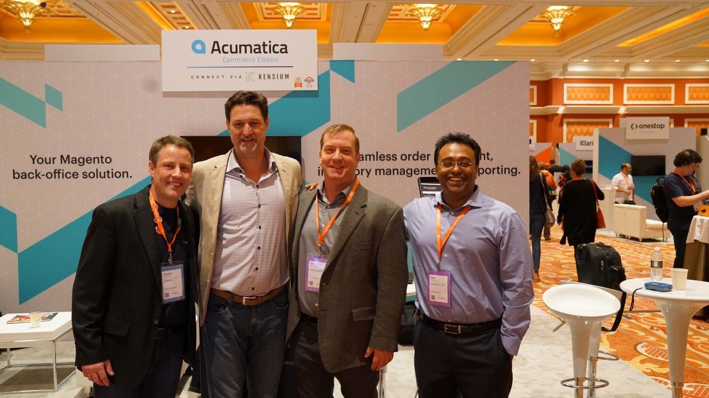 Christian Lindberg, de Acumatica; Mark Lavelle, director ejecutivo de Magento; y Jim Hruska y Rahul Gedupudi, de Kensium Solutions, posan para una foto delante de nuestro stand en el Marketplace el último día de Imagine 2017.