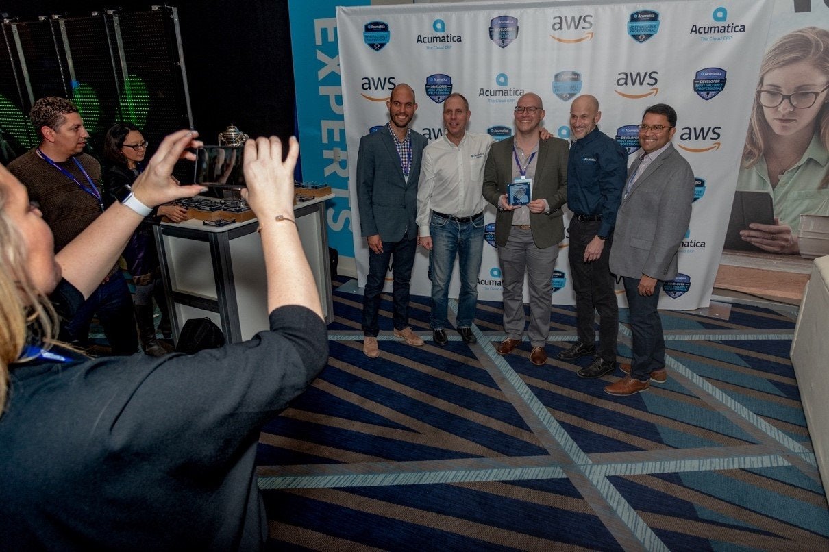 Acumatica’s Jon Roskill, Ajoy Krishnamoorthy and Mark Franks posing with MVP winners during Sunday’s welcome reception