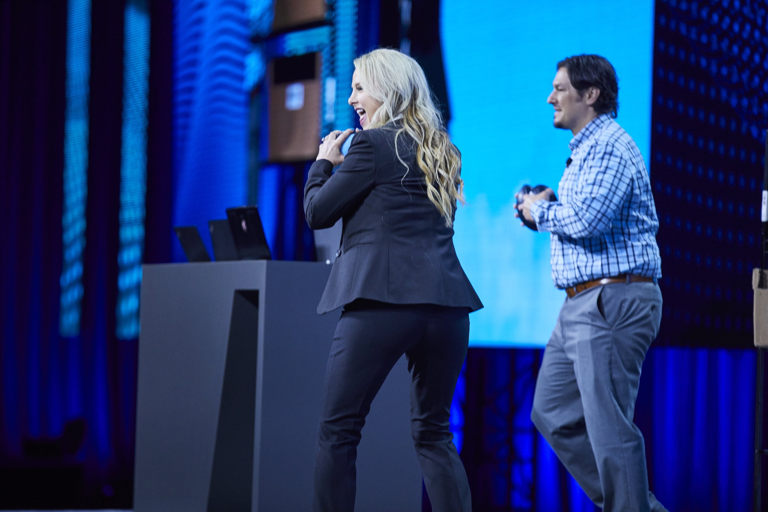 Debra Mignola and Josh Fischer toss footballs during the Day 2 keynote
